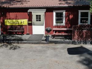 una casa roja con un letrero amarillo delante de ella en Malmköpings Bad & Camping, en Malmköping