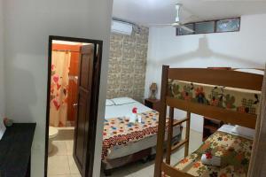 1 dormitorio con 2 literas y espejo en Hostal Casa Taisha en Montañita