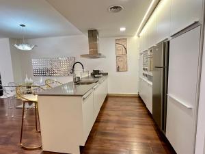 a kitchen with white cabinets and a kitchen island at WeRentVLC - Design Ruzafa - Top location in Valencia
