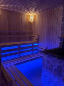 a sauna with a bench and a swimming pool at Bacówka Roztocze Resort & Spa in Zwierzyniec