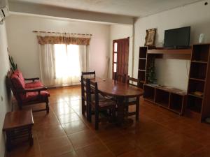 - un salon avec une table, des chaises et une télévision dans l'établissement Posada Chaupihuasi, à Villa Unión