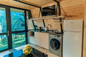 a kitchen with a refrigerator and a washing machine at Paradise Keda in K'eda