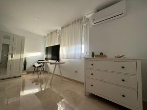 a bedroom with a dresser and a desk with a television at Tokyo Rooms Monsul Habitación PREMIUM con baño privado in Almería