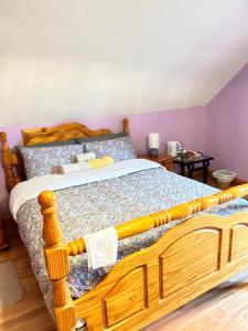 een bed met een houten frame in een slaapkamer bij Ballytigue House in Droíchead an Chláir