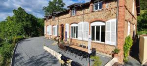 a large brick building with a street in front of it at Les Dortoirs de la Bastide du Puech in Cransac