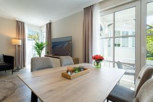 ein Wohnzimmer mit einem Holztisch und Stühlen in der Unterkunft Villa Vesta in Top Lage in Binz