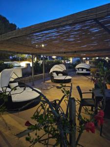 einer Gruppe von Betten unter einer hölzernen Pergola in der Unterkunft Graceland rooms and suites in Capo Vaticano