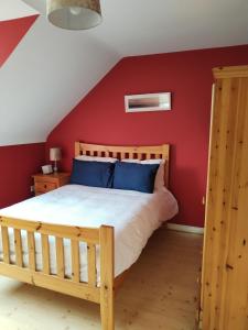 una camera con letto in legno e parete rossa di Bundoran Guesthouse a Bundoran