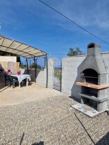 a outdoor oven with a table and a patio at Curmo beach & relax in Le Castella
