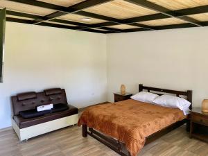 a bedroom with a bed and a chair in it at Cabaña MALAVI Colibrí in Nobsa