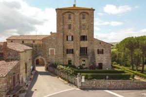 Un gran edificio de piedra con una torre de reloj. en Villa Marta, en Contignano
