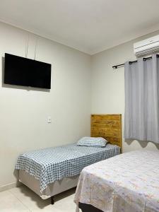 1 dormitorio con 2 camas y TV de pantalla plana en Casa Toledo, en Olímpia
