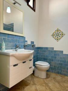 bagno con servizi igienici, lavandino e specchio di Il Golfo di Cofano a Custonaci