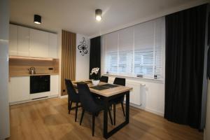 Apartament ARS Platinium Wisła في فيسلا: مطبخ مع طاولة طعام وكراسي