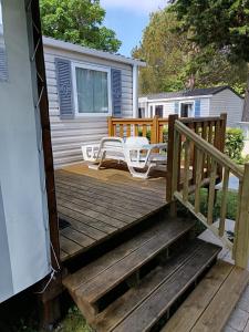 une terrasse en bois avec deux chaises et une table dans l'établissement MH 329 Camping Bois Dormant, à Saint-Jean-de-Monts 17 autres photos