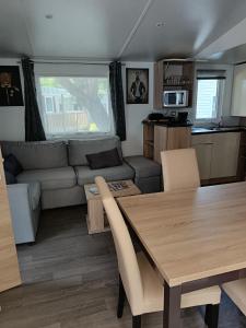 un salon avec une table et un canapé dans l'établissement MH 329 Camping Bois Dormant, à Saint-Jean-de-Monts