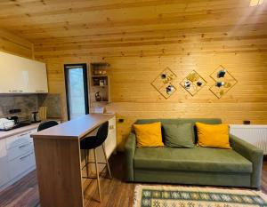 a green couch with yellow pillows in a kitchen at M&M House Kazbegi in Kazbegi +17 photos
