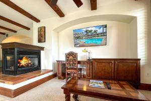 a living room with a fireplace and a table at Heated Pool & Hot Tub Access, Walk 2 Omni Resort, Free Parking, Wi-Fi, Washer & Dryer in Encinitas