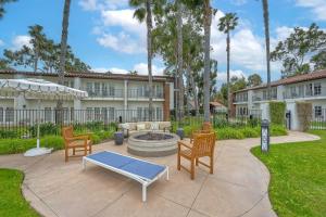 a patio with chairs and a fire pit in front of a building at Heated Pool & Hot Tub Access, Walk 2 Omni Resort, Free Parking, Wi-Fi, Washer & Dryer in Encinitas