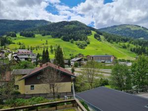 a village with a green hill in the background at Haus Lilly by Globalimmoservice in Bad Kleinkirchheim