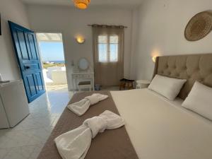 una camera da letto con un grande letto bianco con asciugamani di ANCHOR a Provatas