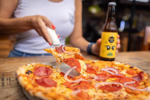 a person eating a slice of pizza on a table at Viajero San José Hostel in San José