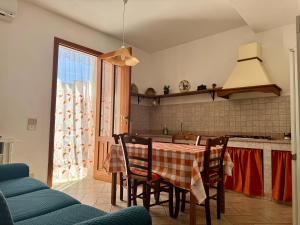 cocina con mesa, sillas y ventana en Il Golfo di Cofano, en Custonaci