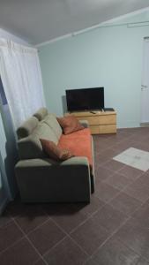 a living room with a couch and a television at Ferienwohnung Irina in Ližnjan