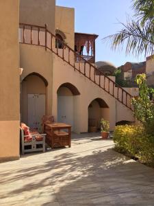 a building with a balcony with a wooden table at Garden view guest house in Luxor