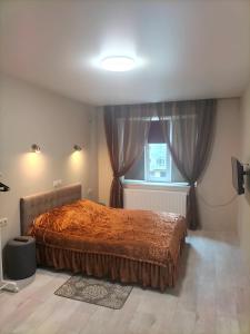 Un dormitorio con una cama grande y una ventana en ALIANCE апартамети в центрі міста. en Ivano-Frankivsk