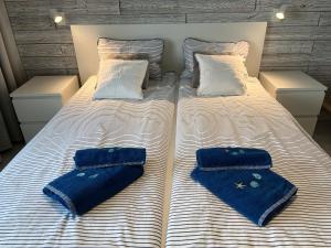 a large bed with two pairs of blue shoes on it at Darba 2 in Darłowo +33 photos