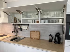 a kitchen with white cabinets and a sink at Darba 2 in Darłowo