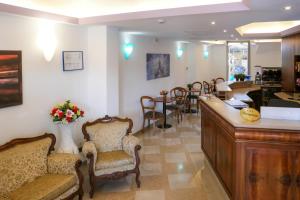 a waiting room with chairs and a counter and a bar at Hotel alla giustizia in Mestre