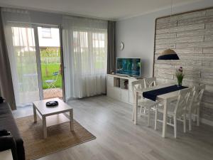 a living room with a table and chairs and a television at Darba 2 in Darłowo