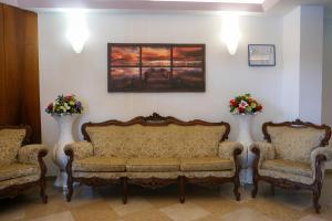 a waiting room with a couch and two chairs at Hotel alla giustizia in Mestre