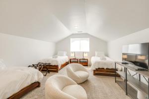 a white room with two beds and a television at Spacious Bellemont Cabin with Jacuzzi and Mtn View! in Bellemont