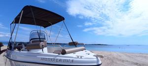 una barca seduta sulla spiaggia con il cielo di NOCE Luxury Villas Resort a Vourvourou
