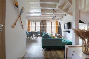 a living room with a green couch and a dining room at Ale Lipa - Ostoja Bukowo in Borowy Młyn