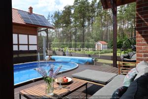 a patio with a table and a swimming pool at Ale Lipa - Ostoja Bukowo in Borowy Młyn