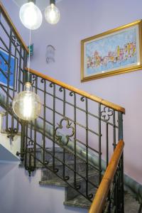 a staircase with a wrought iron rail and a chandelier at Hotel alla giustizia in Mestre