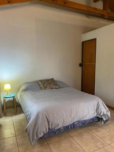 - une chambre avec un lit, une table et une lampe dans l'établissement Casitas patagonicas, à Villa La Angostura