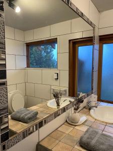 La salle de bains est pourvue de 2 lavabos et d'un grand miroir. dans l'établissement Casitas patagonicas, à Villa La Angostura