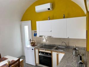 a kitchen with white cabinets and a sink at Casa Ginny in Ospedaletti +5 photos