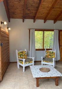 - un salon avec deux chaises et une table dans l'établissement Casitas patagonicas, à Villa La Angostura