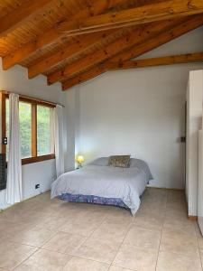 - une chambre avec un lit dans une pièce dotée de plafonds en bois dans l'établissement Casitas patagonicas, à Villa La Angostura