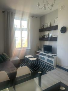 a living room with a couch and a television at HStyle Apartament Mikolowska 9 in Katowice