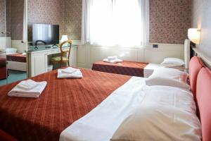 a hotel room with two beds and a television at Hotel alla giustizia in Mestre