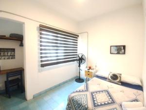 a bedroom with a window with blinds on it at Hostel Hospedarte Chapultepec in Guadalajara