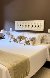 - une chambre avec un grand lit blanc et une tête de lit dans l'établissement Pousada Da Pedra, à Campos do Jordão