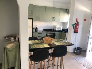 a kitchen with a table with four chairs and a counter top at VIVENDA AZUL in Monchique